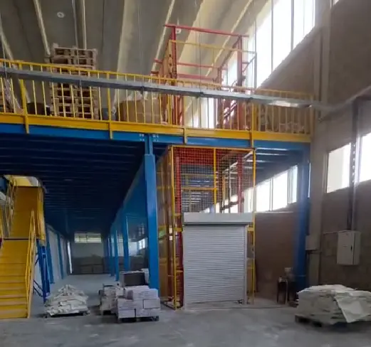 Mezzanine floor with rail guided goods lift and electric roller shutter